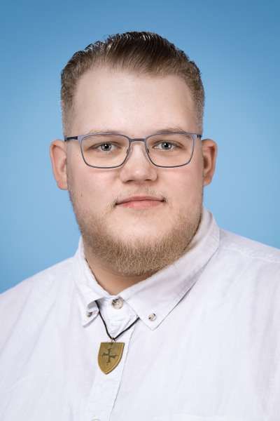 Ein Mann mit Brille und Bart trägt ein weißes Hemd.