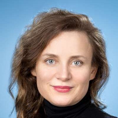 Eine Nahaufnahme des Gesichts einer Frau, die einen schwarzen Rollkragenpullover trägt.