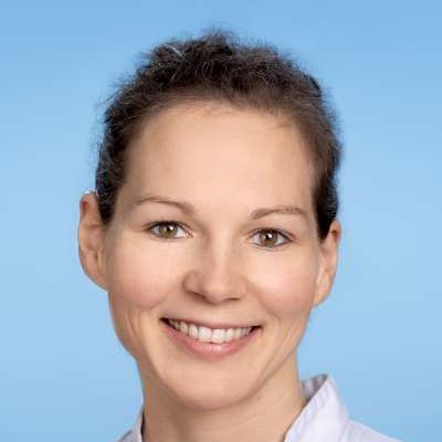 Eine Frau in einem weißen Hemd lächelt in die Kamera.