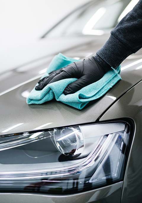 A Person Is Cleaning the Hood of A Car with A Towel — AJ Automotive Services Bowral in Bowral, NSW