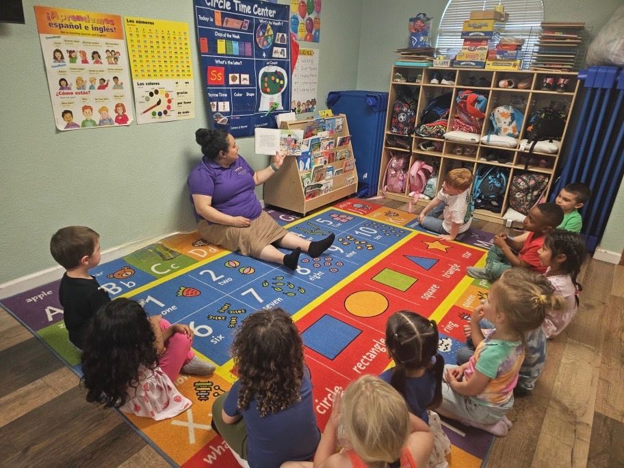 A woman is reading a book to a group of children