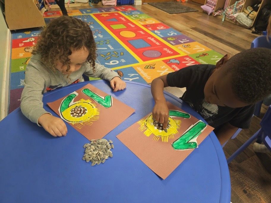 A boy and a girl are sitting at a table making crafts