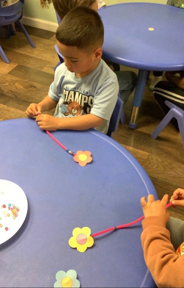 A boy wearing a shirt that says champ is sitting at a table