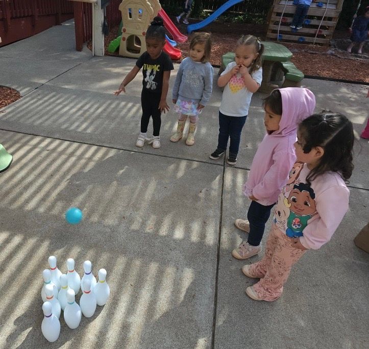 A group of young children are playing a game of bowling