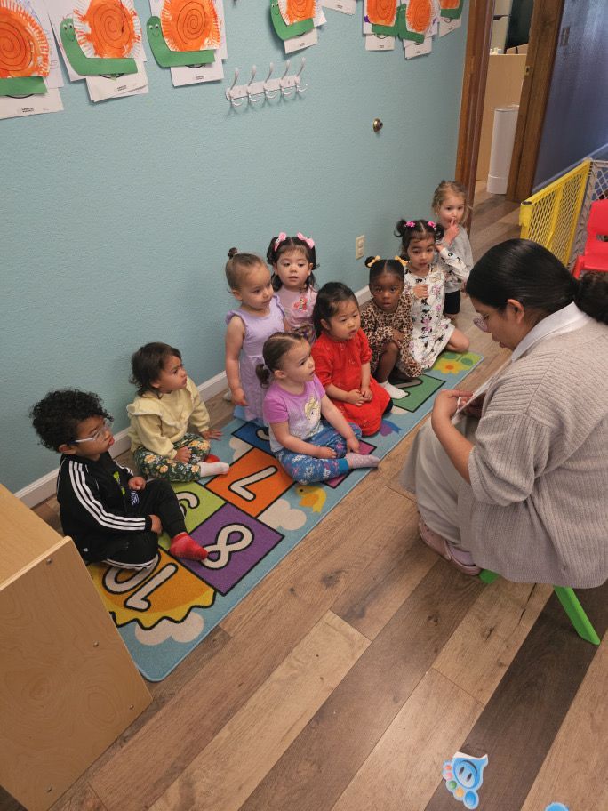 A woman is reading a book to a group of children