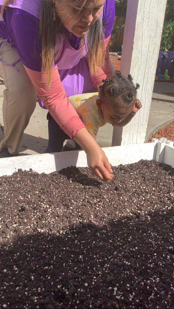 A woman and a child are working in a garden.