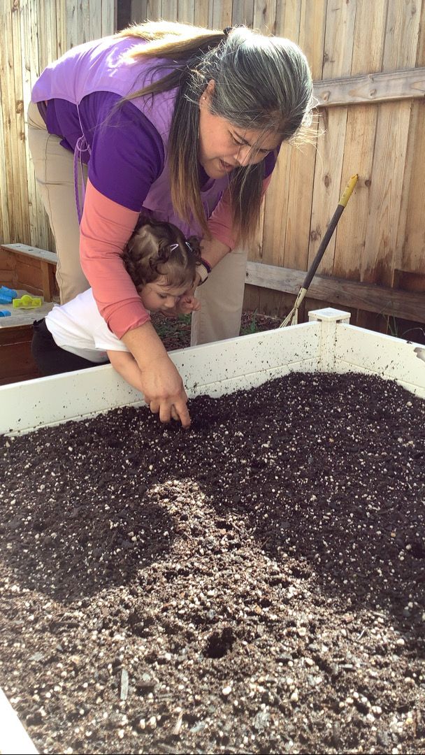 A woman and child are working on a pile of dirt