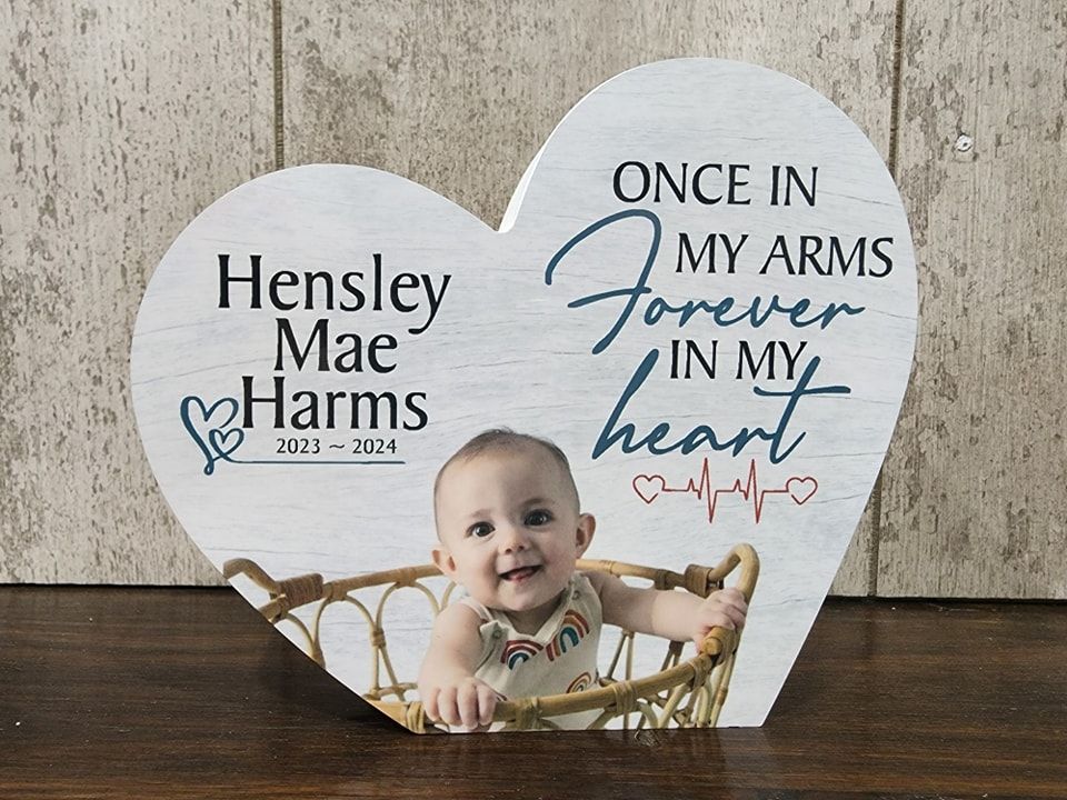 Heart-shaped memorial with a baby's photo, name, dates, and 