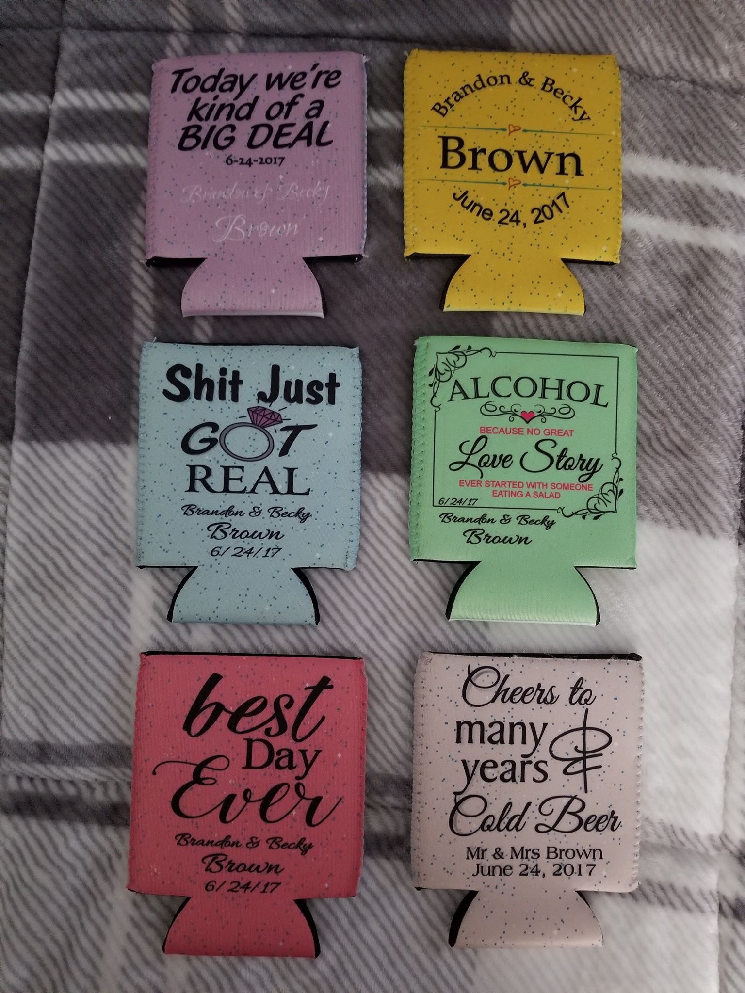 Six colorful beverage holders with various phrases and dates.