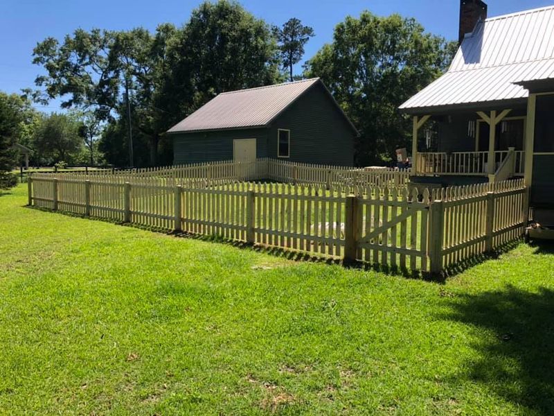 A house with a porch and a fence in front of it