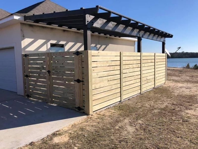 A wooden fence with a pergola on top of it