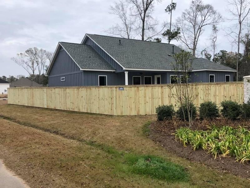 A house with a wooden fence in front of it.