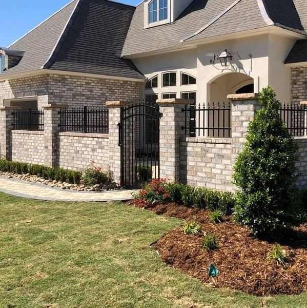 A large white house with a brick fence around it