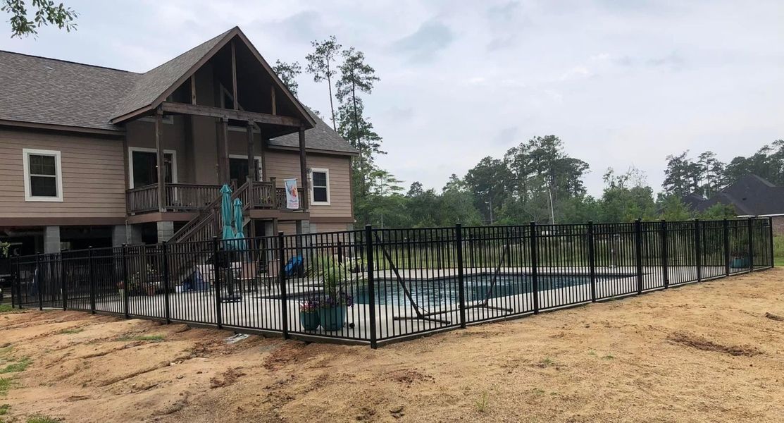 A house with a pool and a fence around it.