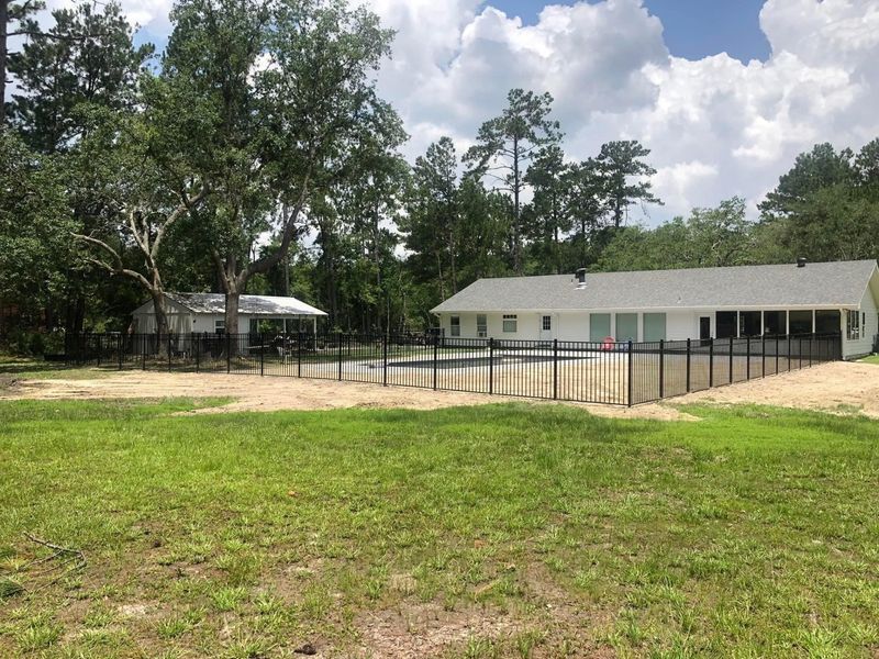 A house with a pool and a fence around it
