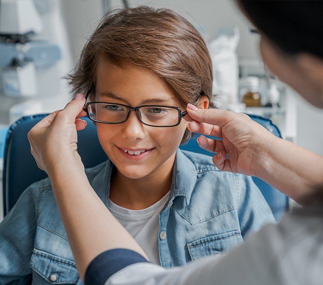 Staff Assisting A Kid With Eyeglass — Defiance, OH — Defiance Vision Care
