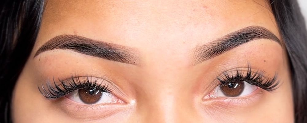 A close up of a woman 's eyes and eyebrows after a microblading treatment.