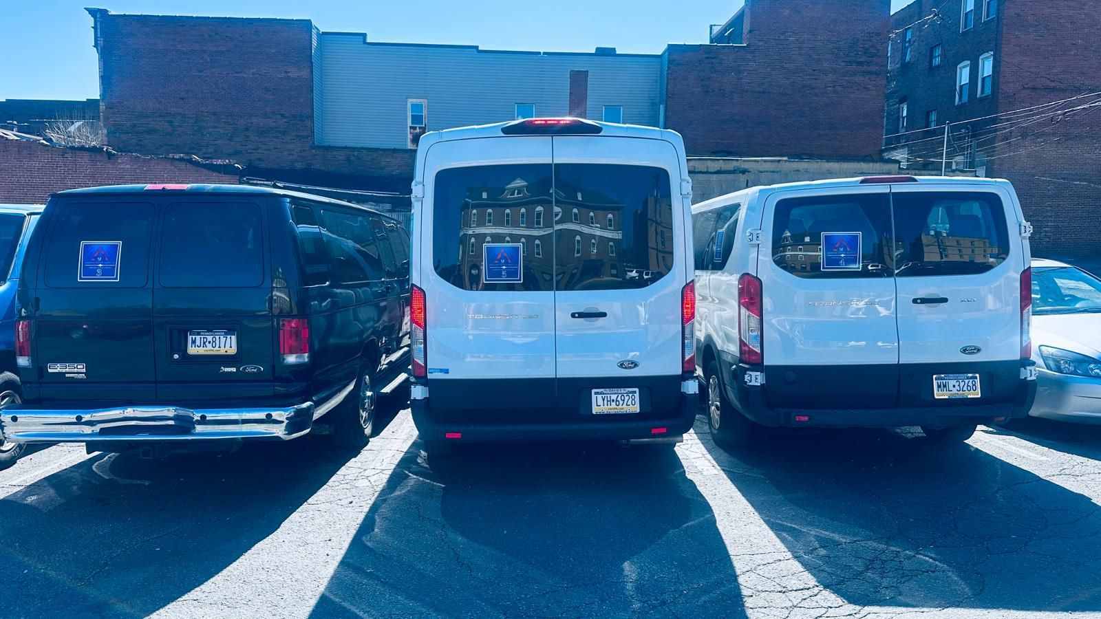 Three vans are parked next to each other in a parking lot.