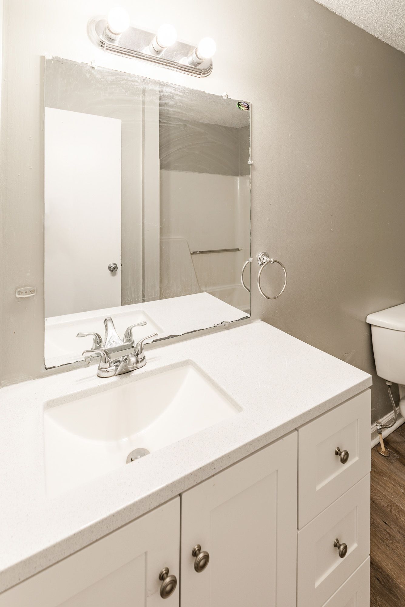 A bathroom with a sink , mirror and toilet.