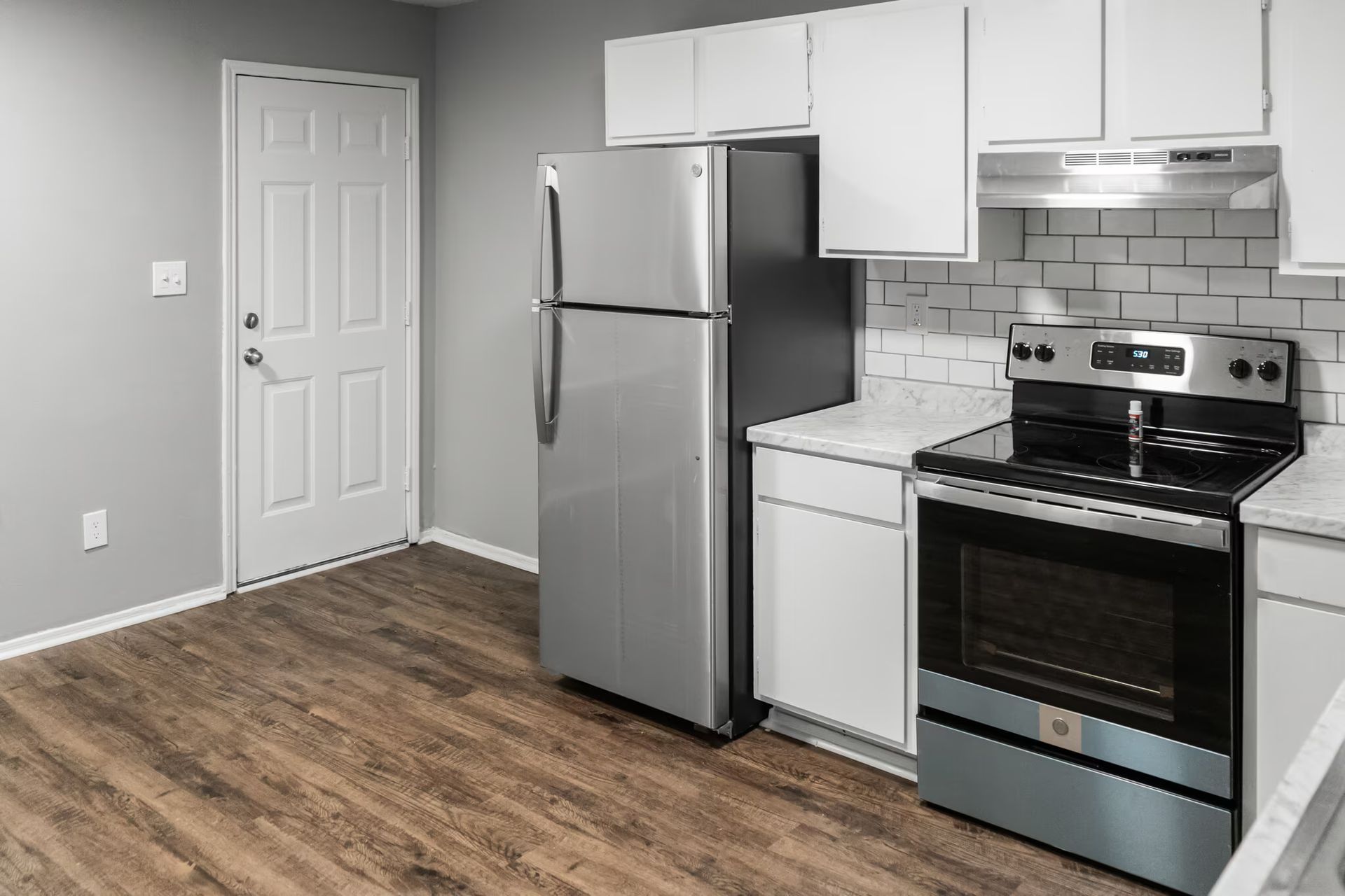 A kitchen with a refrigerator , stove , and oven.