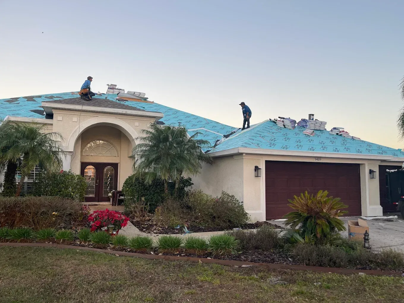 Two men are working on the roof of a house.