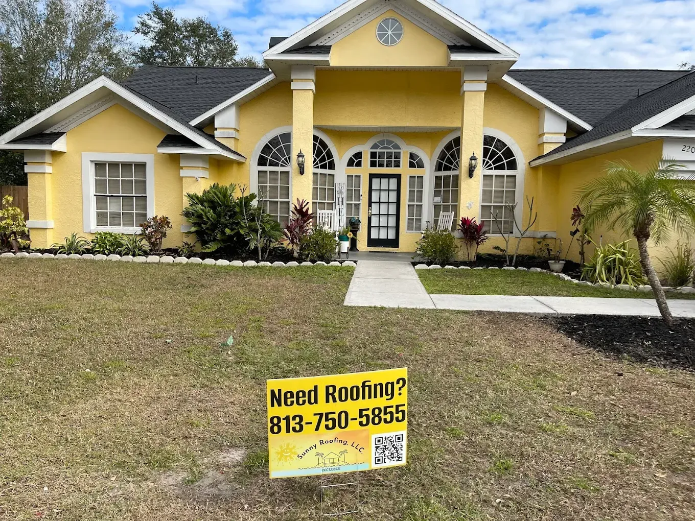 A yellow house with a sign in front of it that says need roofing