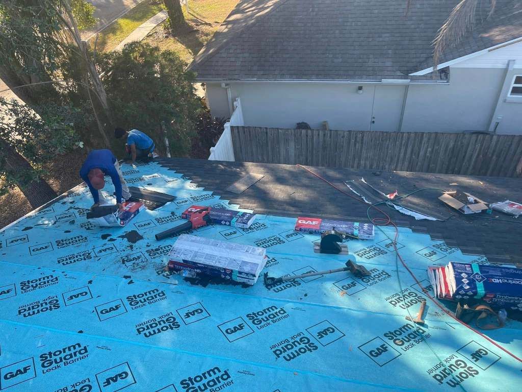 A man is working on the roof of a house.
