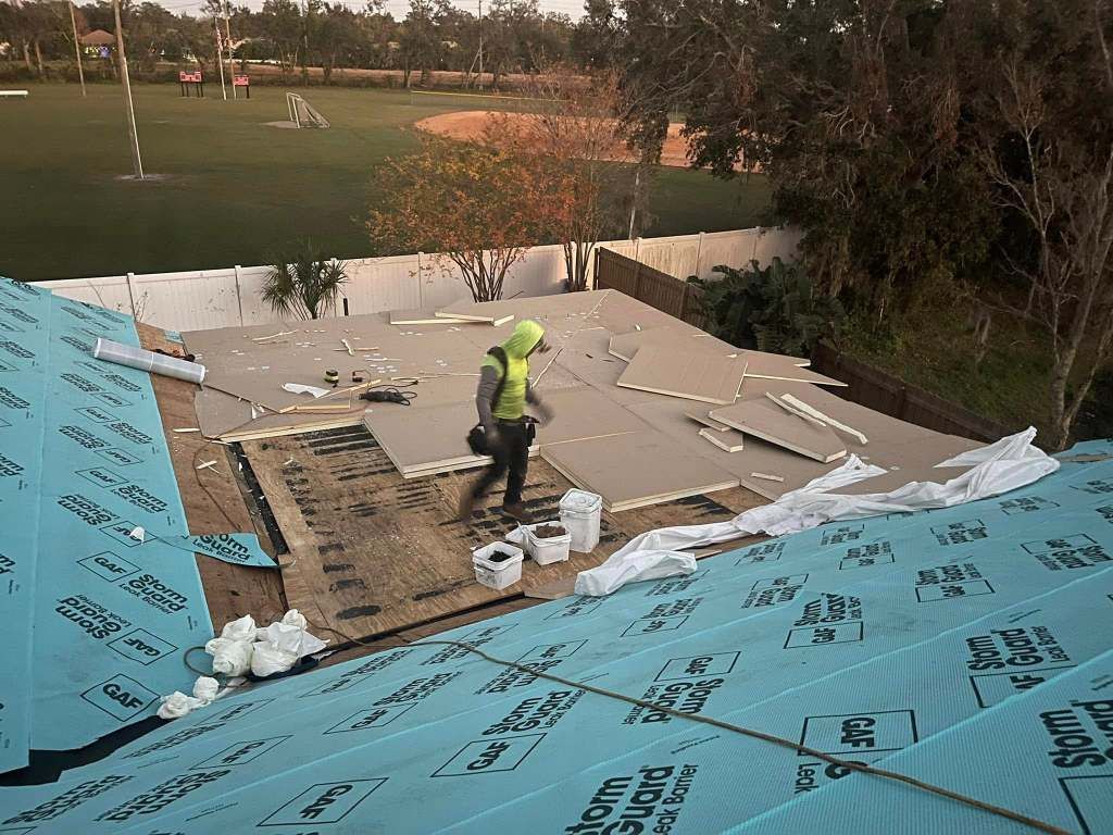 A man is working on the roof of a house.