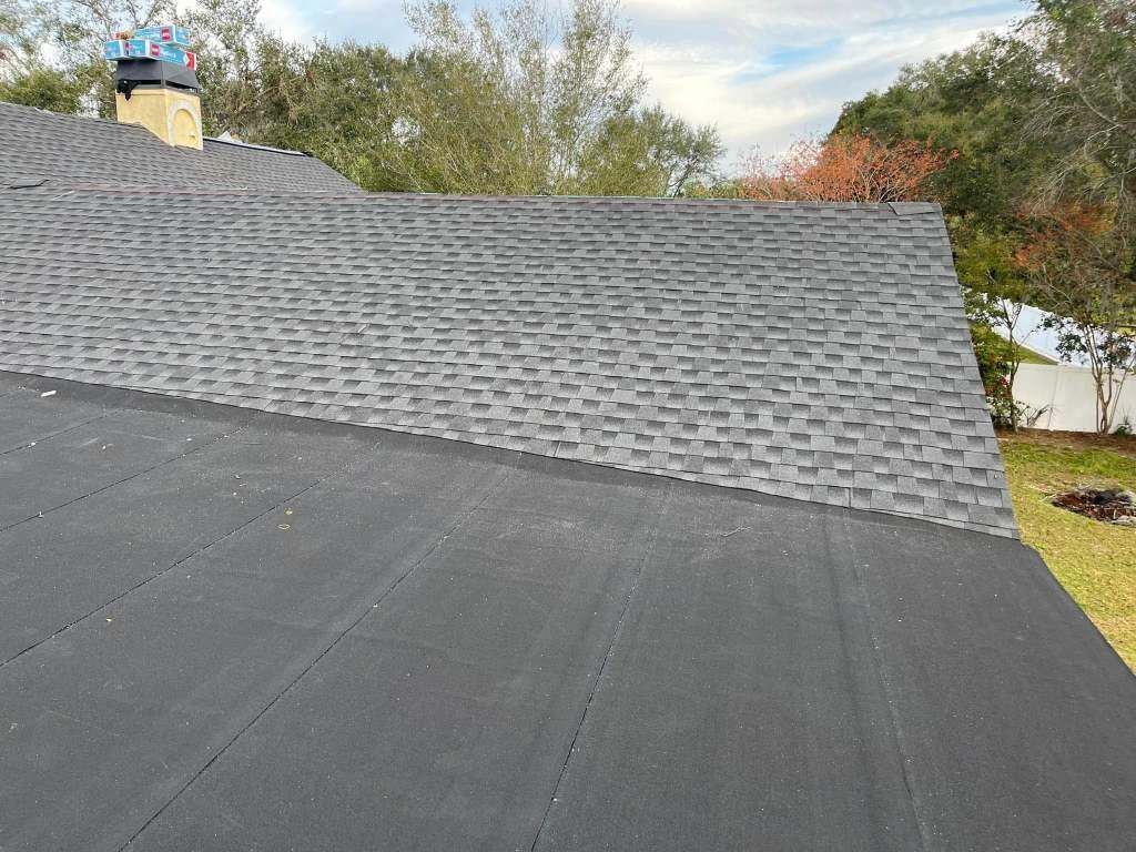 A black roof with a chimney on top of it.