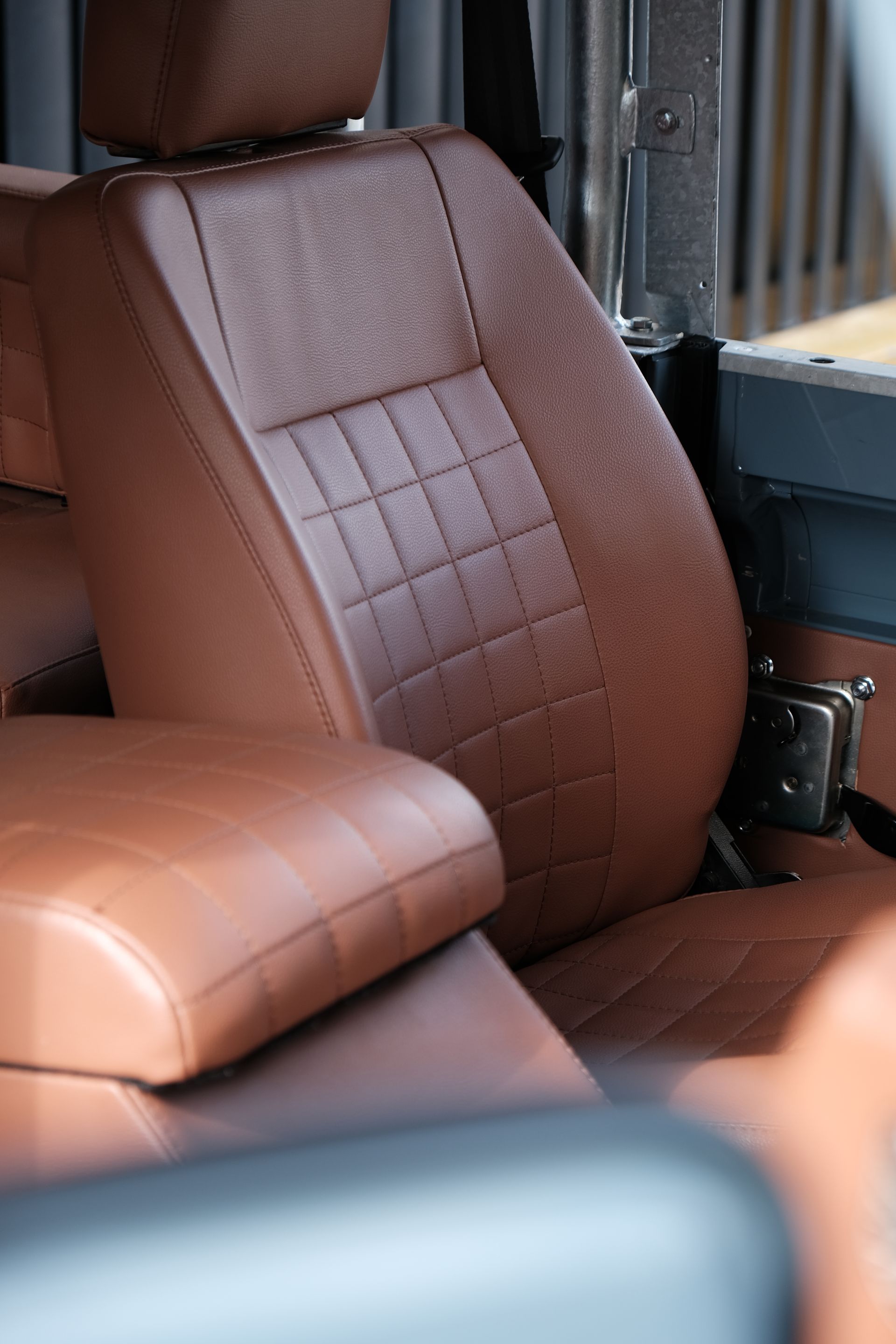 Siège auto en cuir marron avec un motif carré sur le dos.