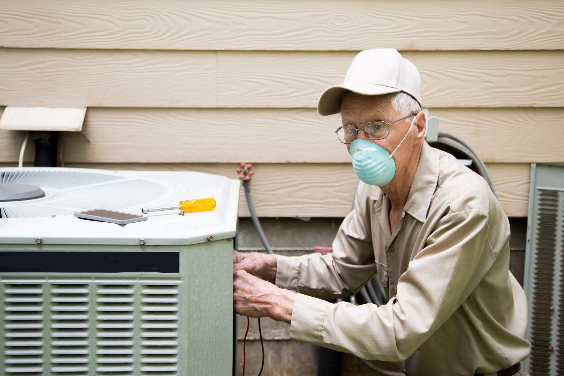 Technician installing an outside AC unit.
