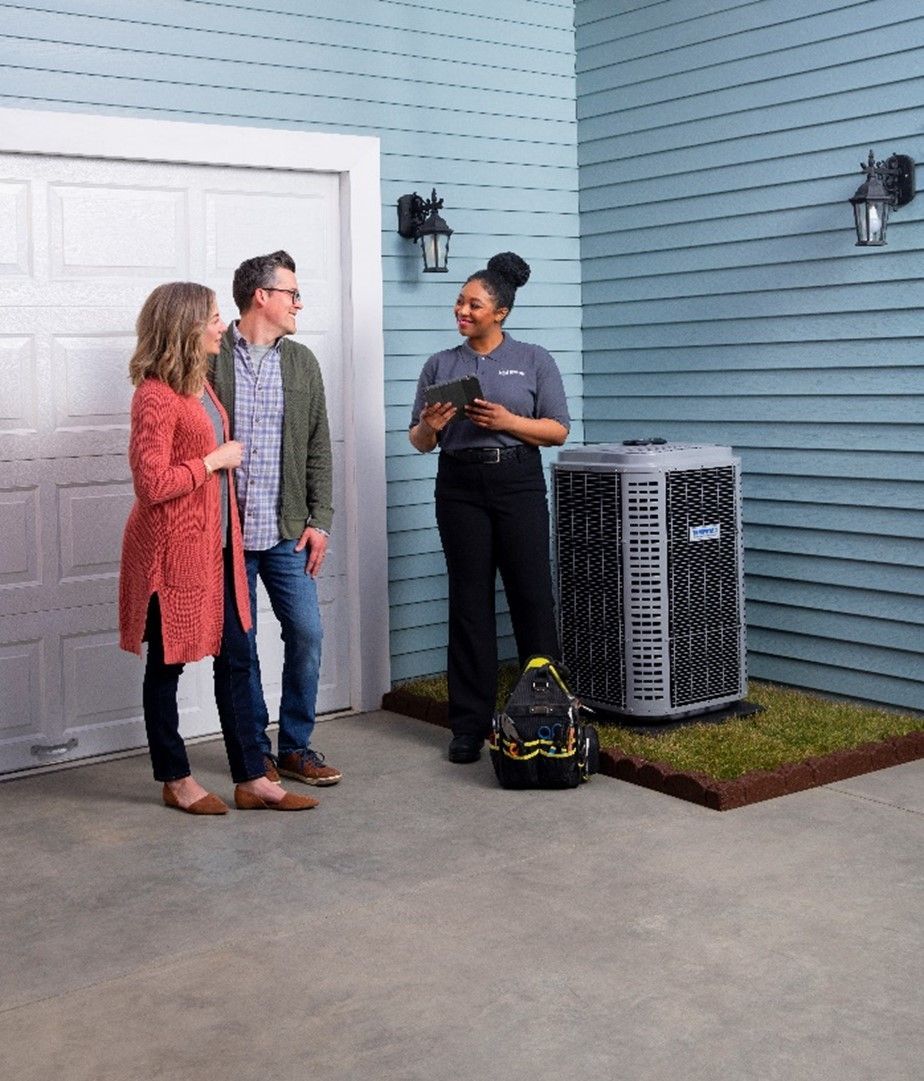 Tempstar dealer standing next to a couple in front of a new AC unit.