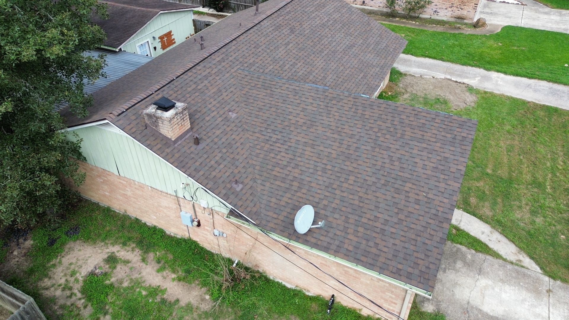 An aerial view of a house with a satellite dish on the roof.