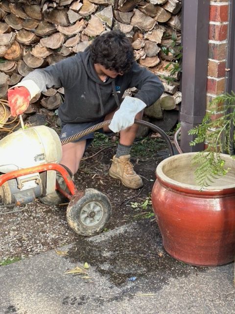 Plumber fitting sink pipe in kitchen — Ringwood, VIC — Dickson Plumbing