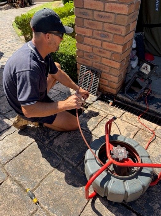 Professional plumber performing drain inspection using video camera equipment