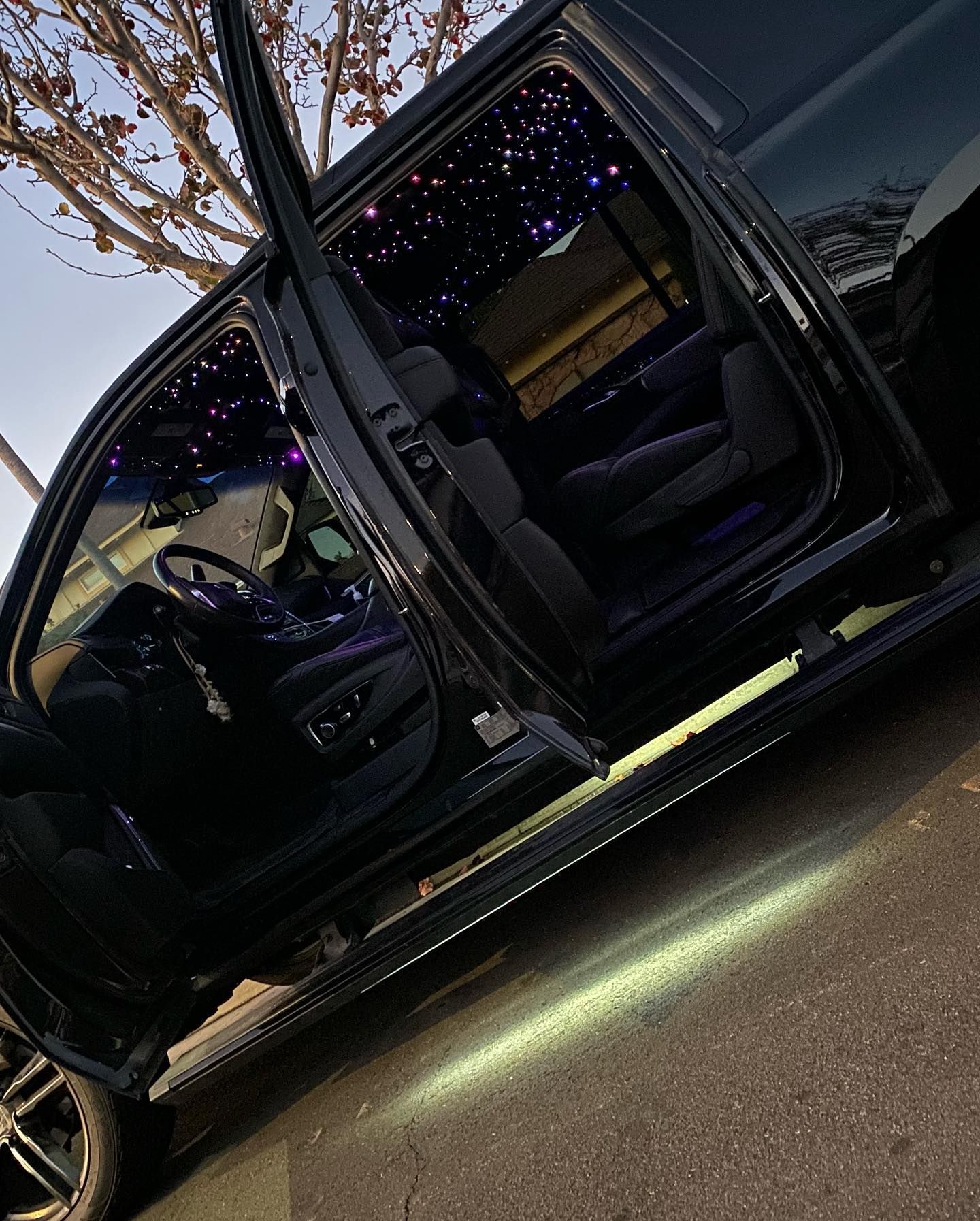 A black van with its doors open is parked on the side of the road.