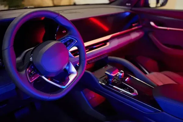 The interior of a car is lit up with purple and blue lights.