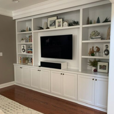 A living room with white cabinets and a flat screen tv