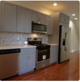 A kitchen with stainless steel appliances and gray cabinets