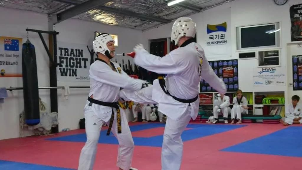 two people are practising martial arts in a gym — Tae Kwon Do Lessons in Port Stephens