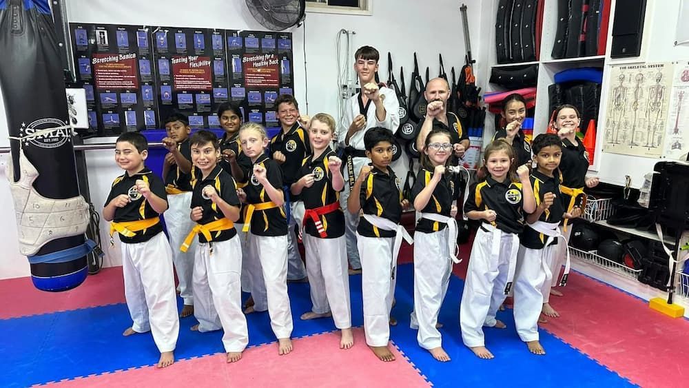 a group of children are posing for a picture in a gym — Tae Kwon Do Lessons in Port Stephens