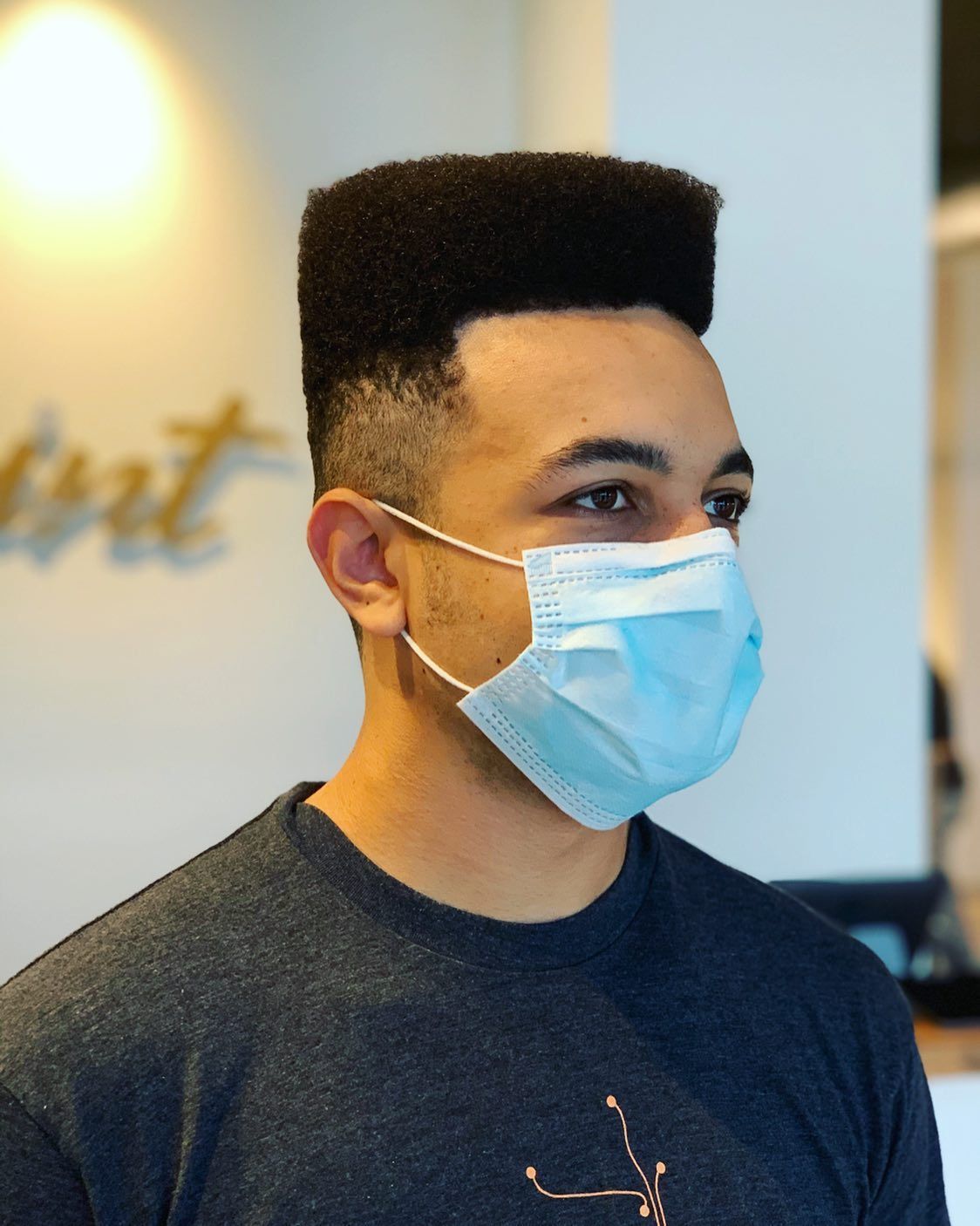 A man wearing a face mask is standing in a room.