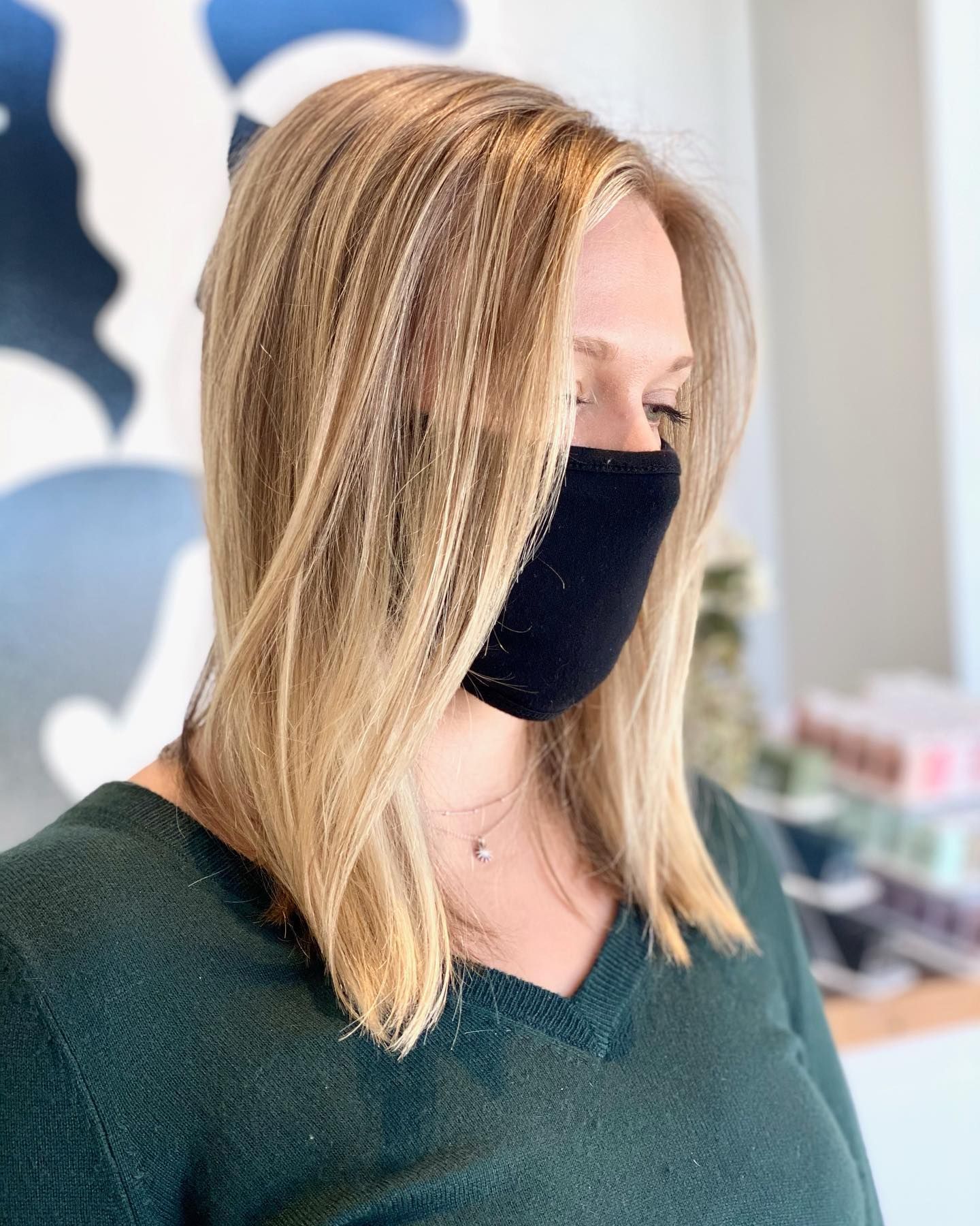 A woman wearing a black face mask and a green shirt.