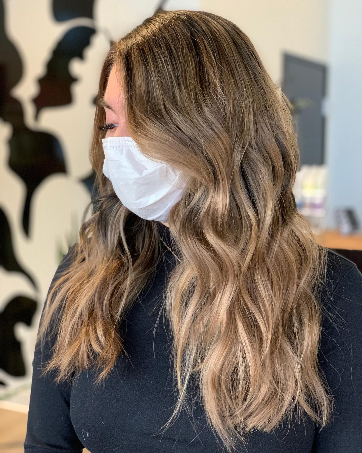 A woman wearing a face mask and a black shirt.