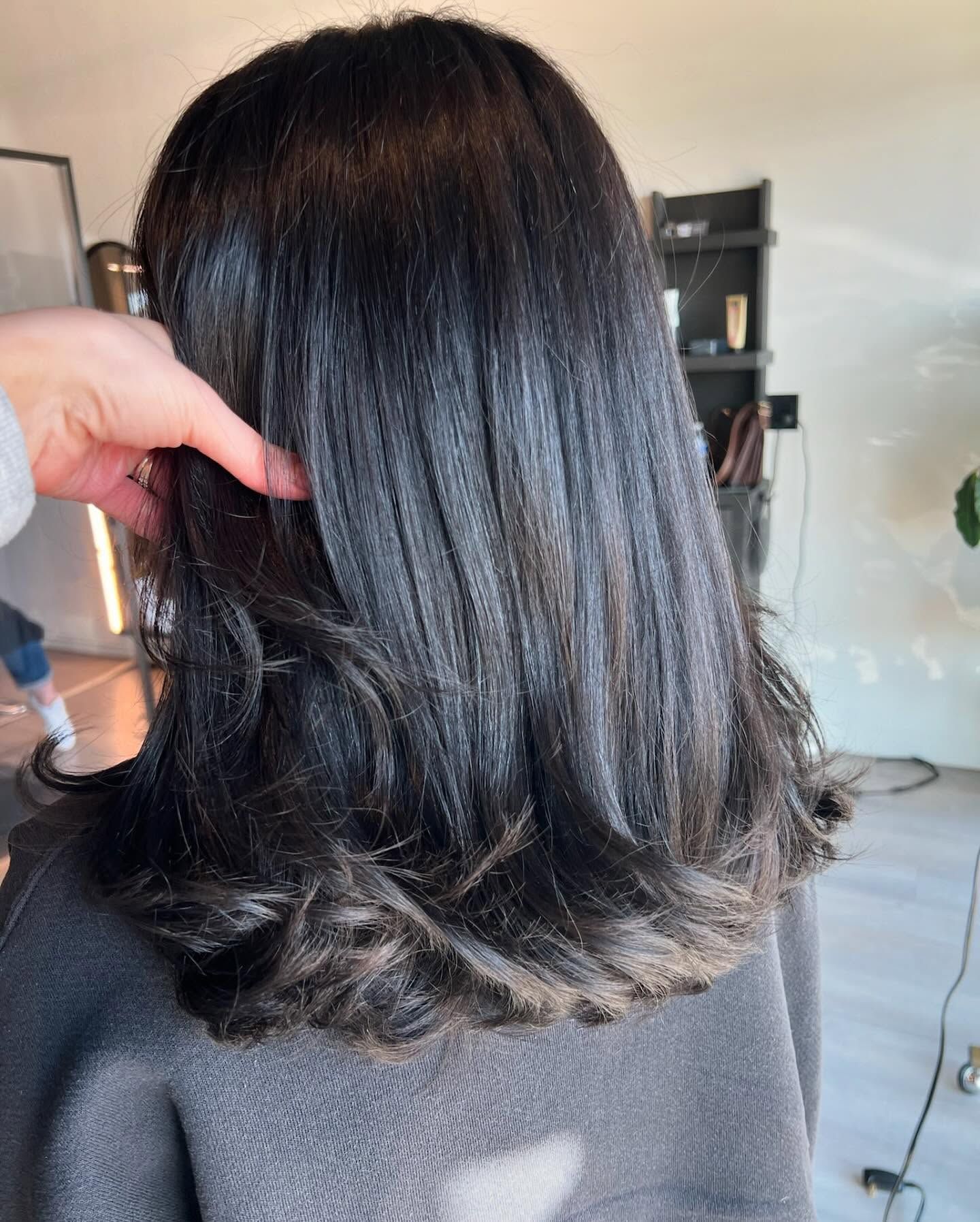 A person is touching a woman 's hair in a room.