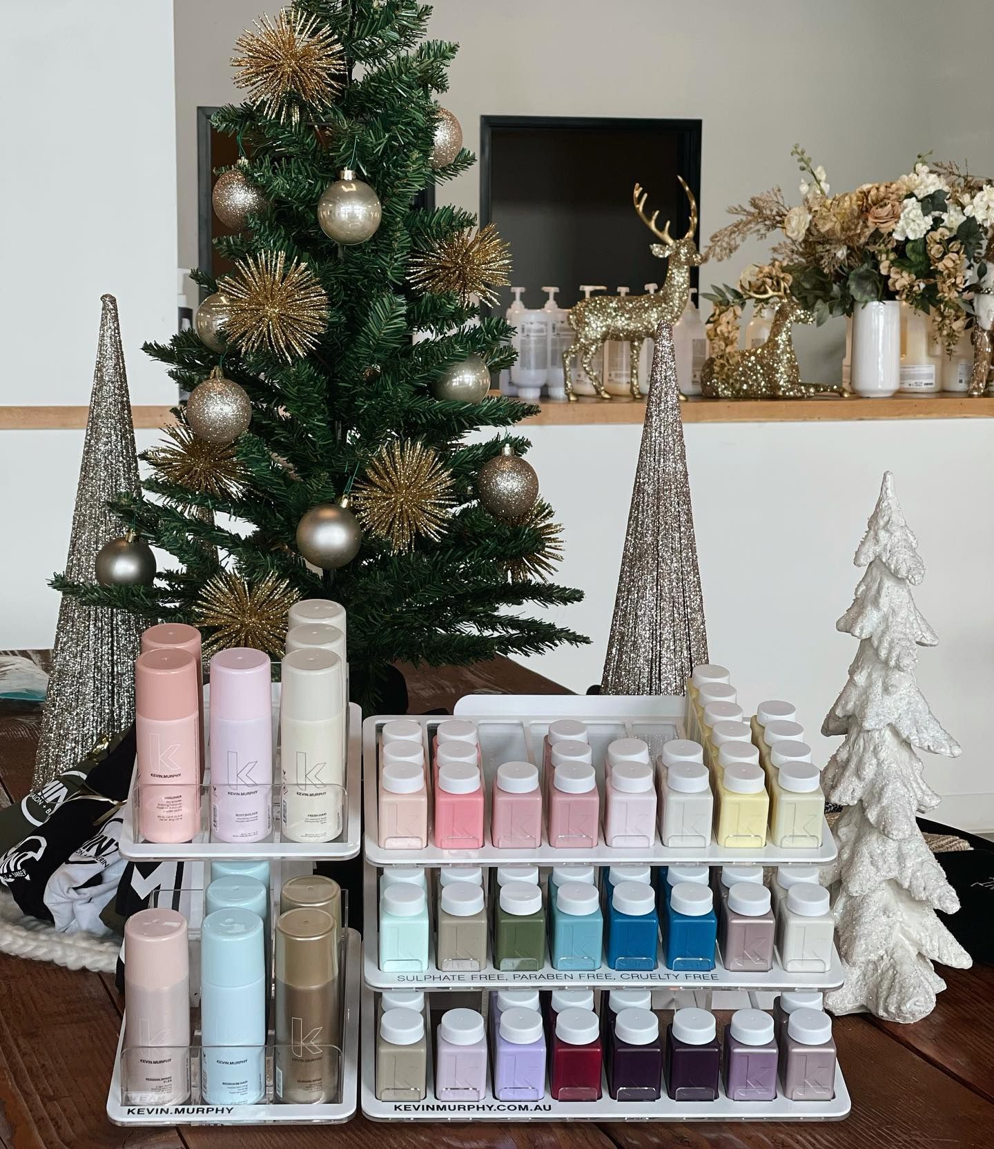 A display of nail polish in front of a christmas tree
