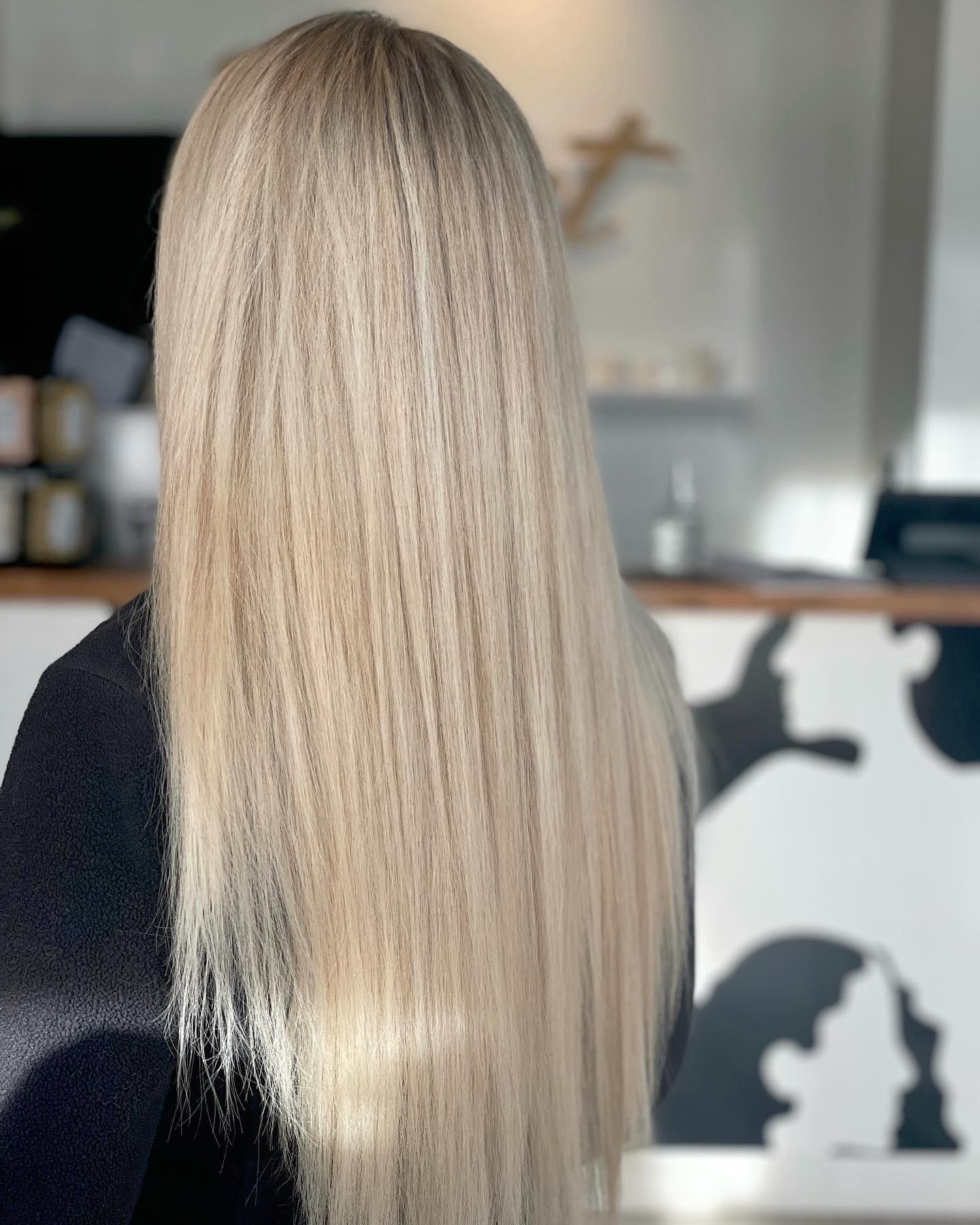 A woman with long blonde hair is sitting in front of a counter.