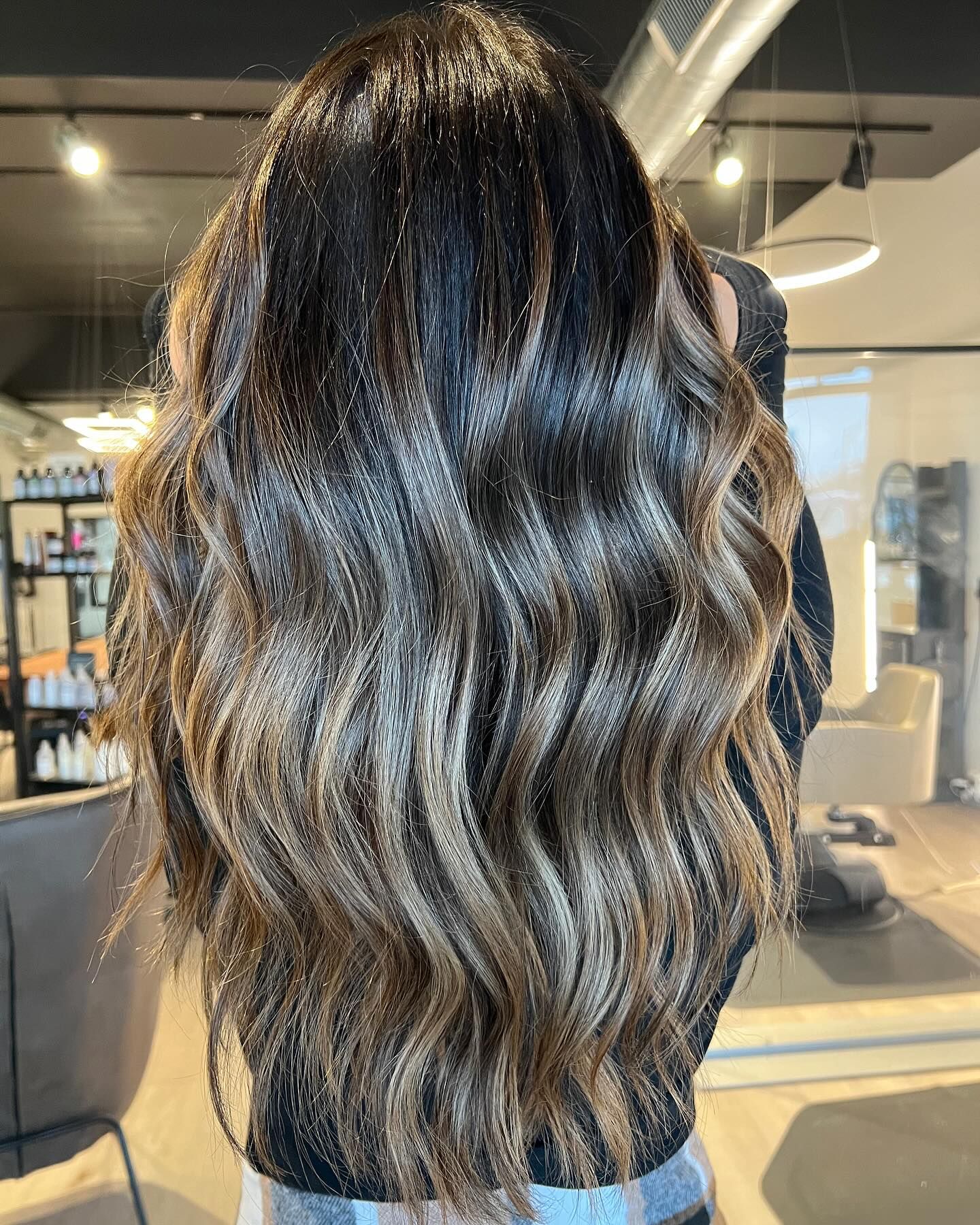 The back of a woman 's hair is shown in a salon.