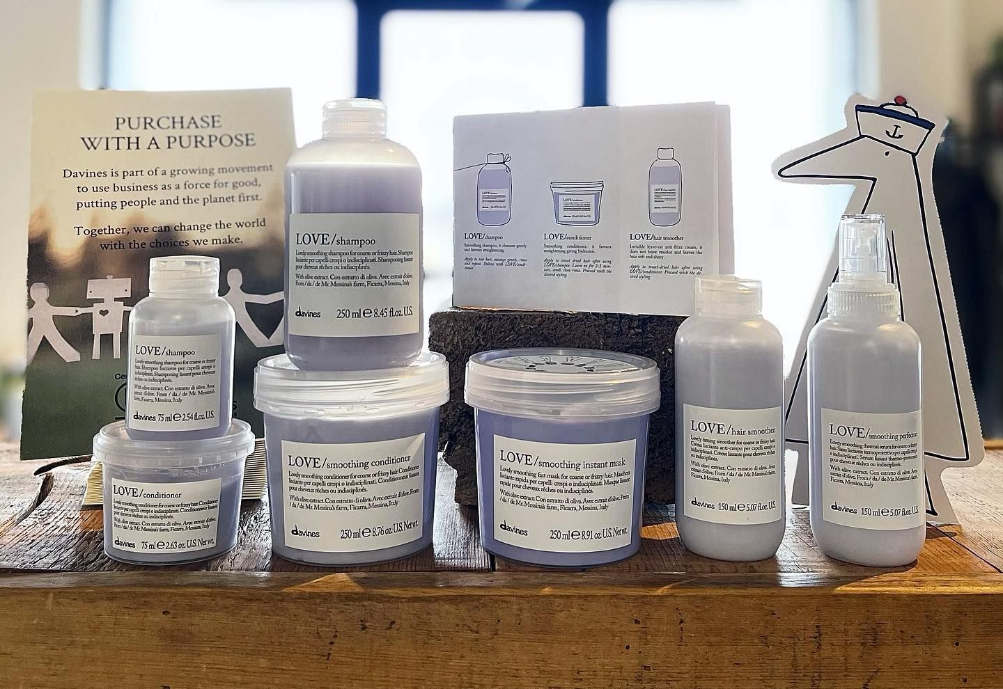 A bunch of bottles on a table with a sign that says purchase with purpose