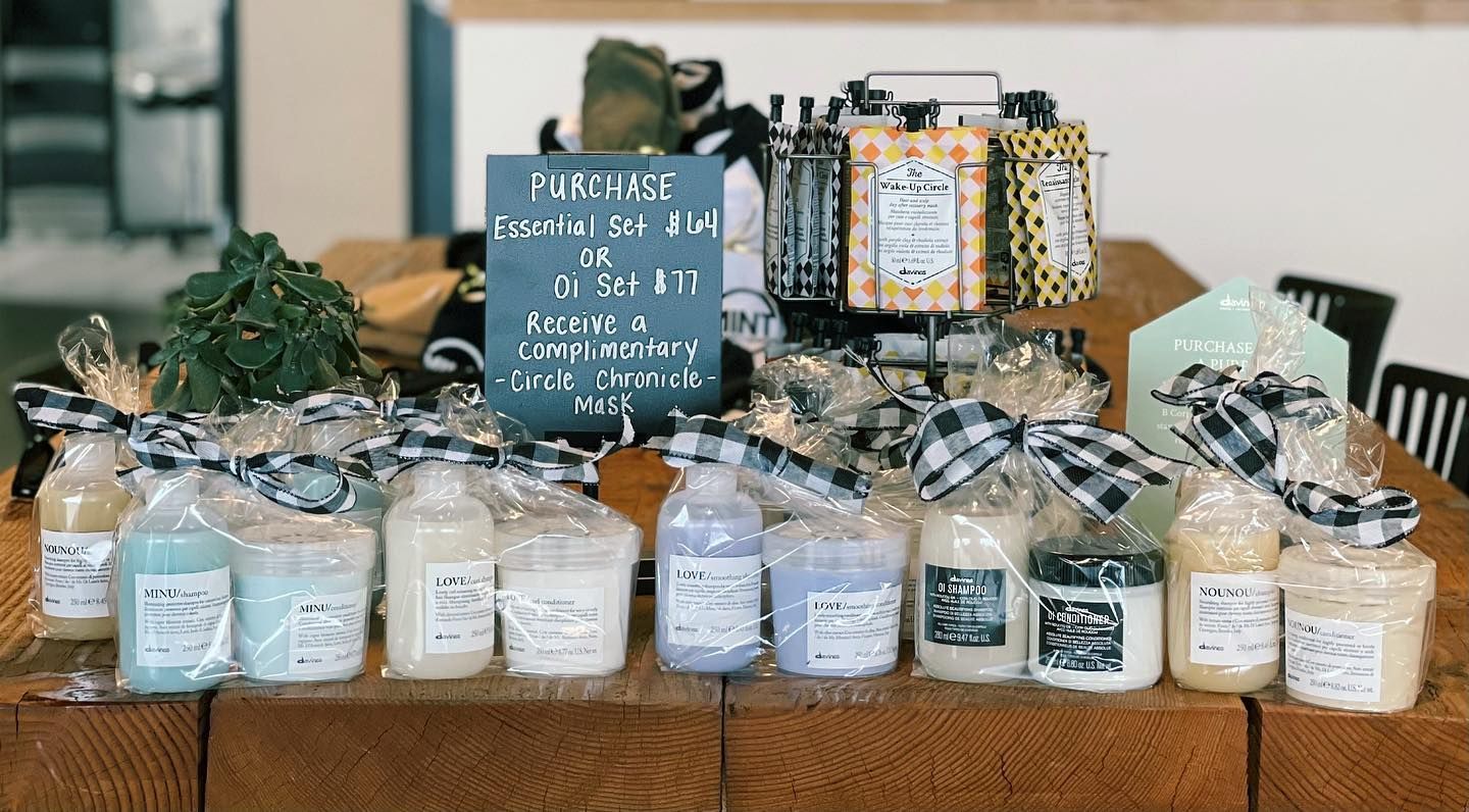 A wooden table topped with a variety of soaps and candles.